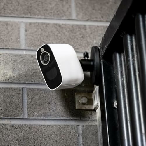 Security camera mounted on a wall with a metal frame